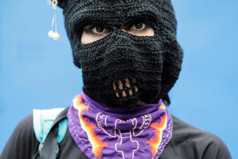 A woman poses for a photo during a march toward Zocalo square to demand justice for the victims of gender violence and femicides in Mexico City. REUTERS/Raquel Cunha    